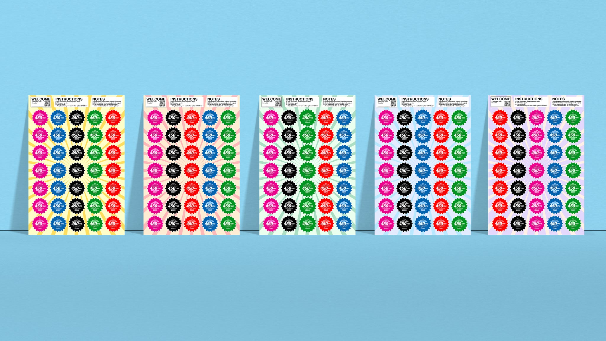 Photograph showing five 8.5 inch by 12.25 inch sticker sheets side by side with different color backgrounds. Each sheet contains 35, multi-colored, starburst-shaped stickers