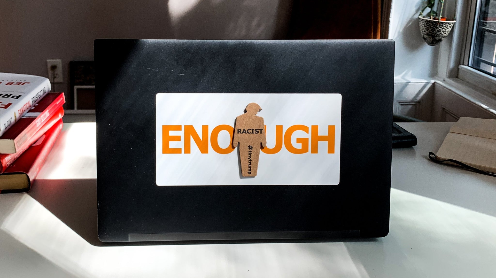 "ENOUGH" tiny trump laptop sticker shown with a "Racist" tiny trump stuck on top