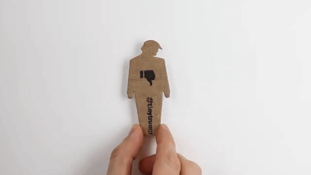 Animation showing how easy it is to peel off the back of a tiny trump and stick it to a wall