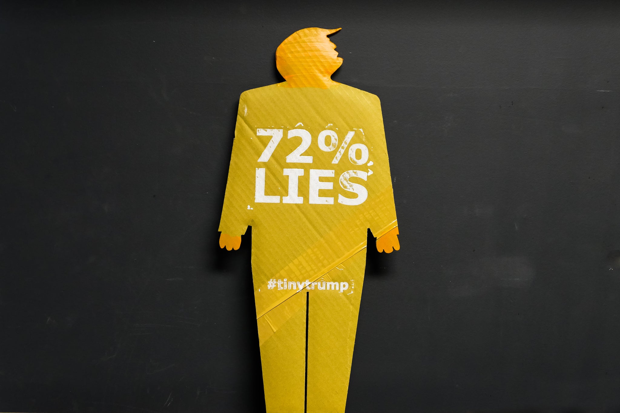 A two foot tall, cardboard tiny trump with the slogan "72% Lies"
