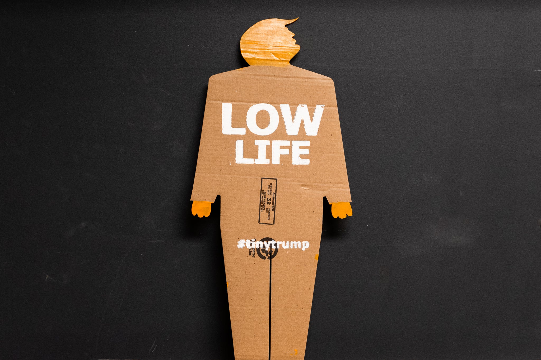 A two foot tall, cardboard tiny trump with the slogan "Low Life"