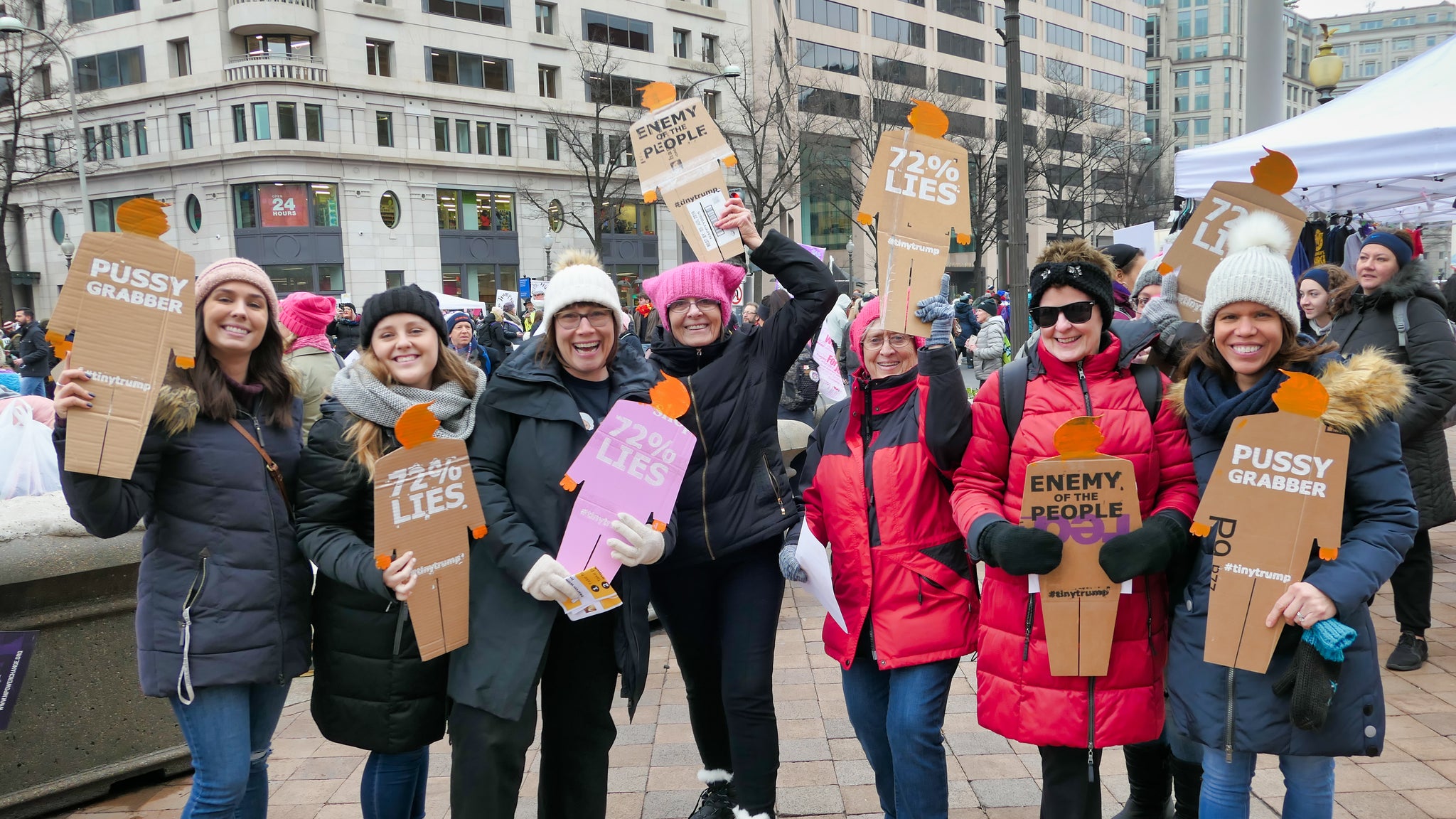 A group of seven protesters at the Women's March in Washington DC holding individual cardboard tiny trumps