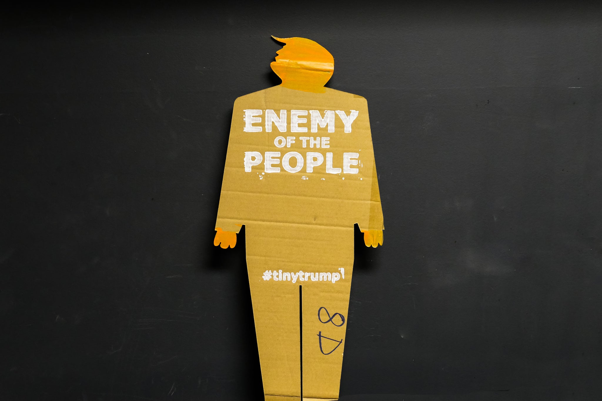 A two foot tall, cardboard tiny trump with the slogan "Enemy of the People"