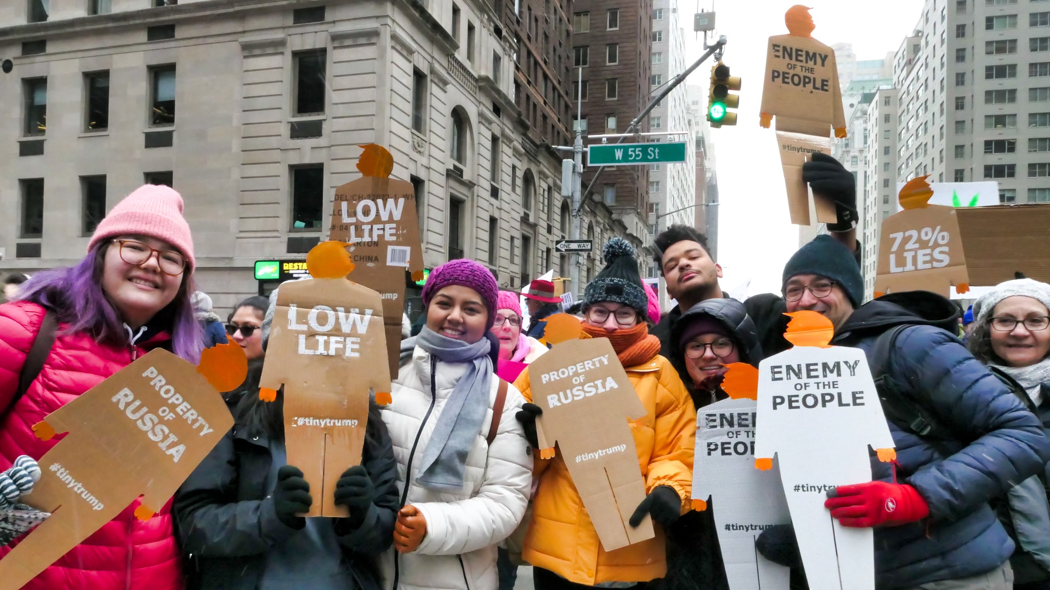 A group of protestors in New York City, each holding their own two foot tall, cardboard tiny trump