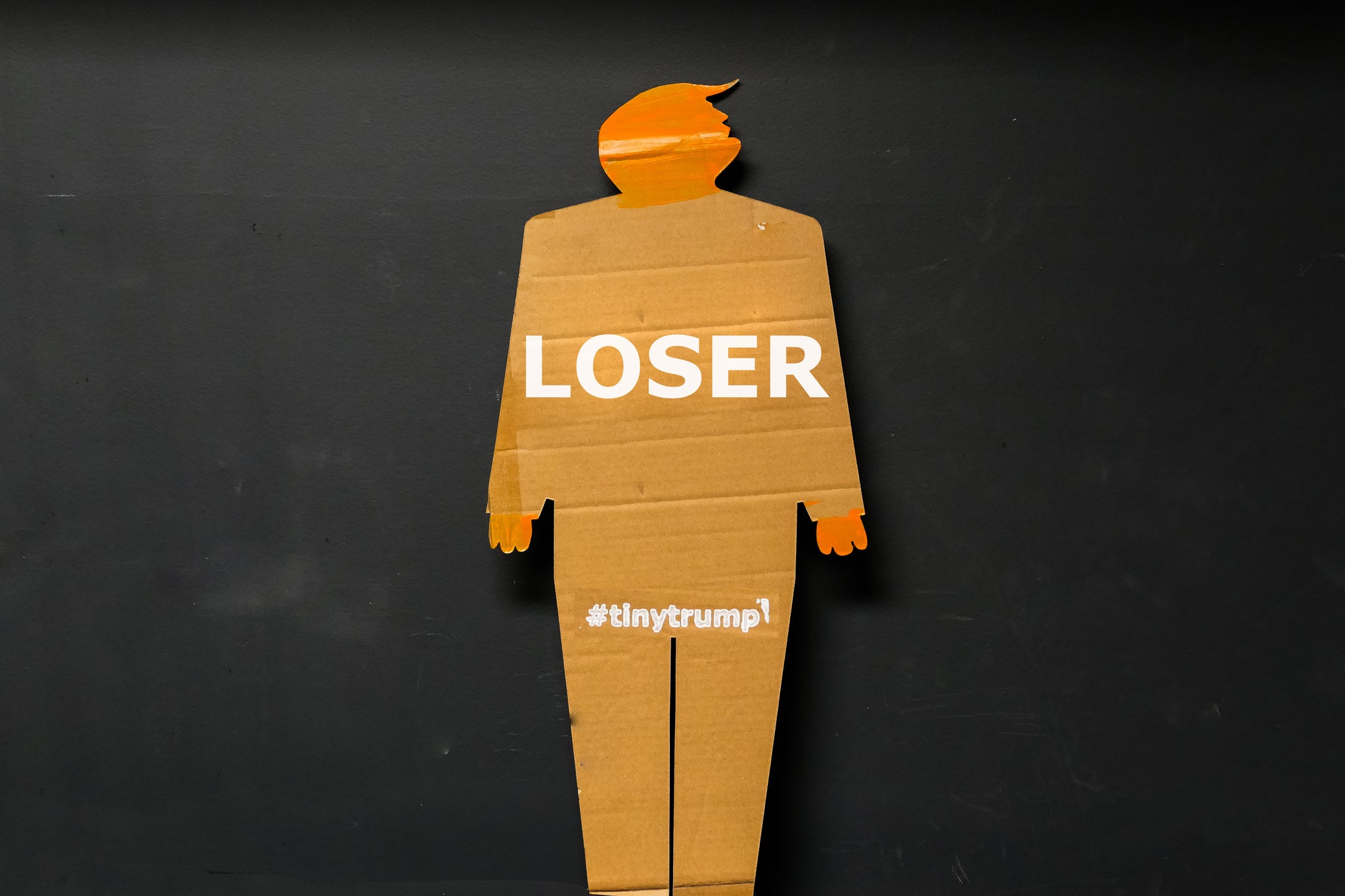 A two foot tall, cardboard tiny trump with the slogan "Loser"